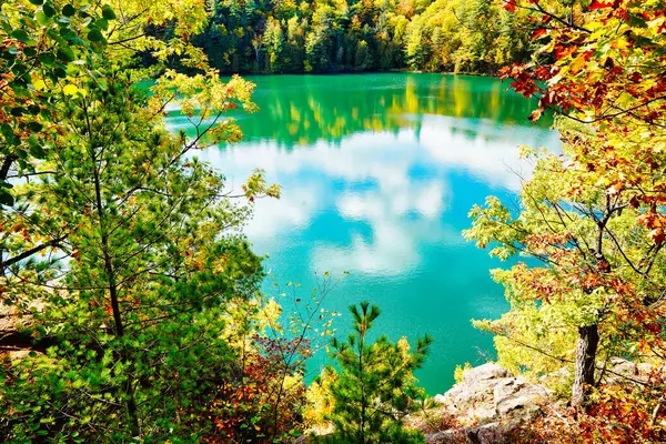 Gatineau Park 'taki göz kamaştırıcı masmavi Pembe Göl Kanada' nın Quebec kentinde Gatineau Park 'ta sonbahar sezonu boyunca muhteşem kırmızı, turuncu ve sarı sonbahar renkleri arasında kayalık bir çıkıntıdan görüldü.