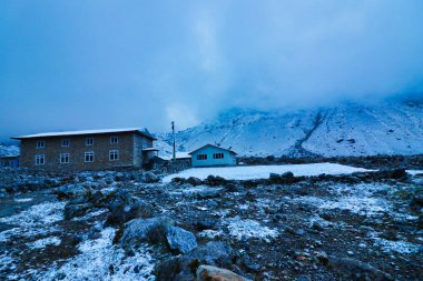 Evening view of the village of Thaknag,4130 meters,after snowfall on route to Base camp of Mera Peak,a 6476 meter high peak in the Khumbu Himalayas,Nepal clipart