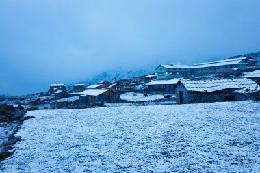 Evening view of the village of Thaknag,4130 meters,after snowfall on route to Base camp of Mera Peak,a 6476 meter high peak in the Khumbu Himalayas,Nepal clipart