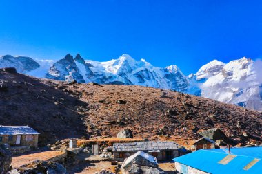 Kuzey Zirvesi Mera Tepesi, 6476 metre sağda ve bitişik Merkez Zirvesi 'nde 6461 metre Mahakulung Tepesi' nde, Khare köyü, Himalayalar, Nepal 'den görülebilen çerçevenin merkezinde 6250 metre uzaklıkta.