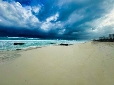 Cancun şehir merkezindeki Playa Chacmool plajındaki Karayip denizinin akarsu mavi suları üzerinde sersemletici kara fırtına bulutları, Cancun, Quintana Roo, Meksika