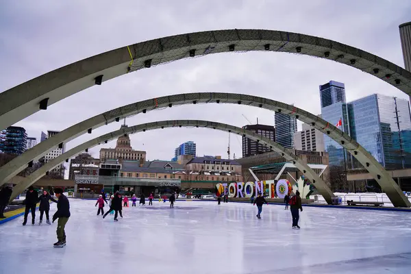 27 Şubat 2023, Toronto, Kanada-sakinleri ve Toronto ziyaretçileri, kışın Toronto, Ontario, Kanada 'da Belediye Binası' nın arka planında Nathan Phillips Meydanı 'nda buz pateni pistinin keyfini çıkarırken,