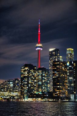 Toronto, Ontario, Kanada 'da Toronto' da Ontario Gölü 'ndeki Toronto Adası' ndan görülen CN kulesiyle Toronto 'nun muhteşem ikonik şehir siluetinin muhteşem gece görüntüsü.