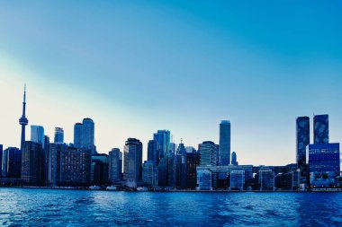 Toronto City Skyline with its iconic CN Tower and other landmark buildings in the financial district seen during late evening from the Ward's island ferry on Lake Ontario in Toronto,Ontario,Canada clipart