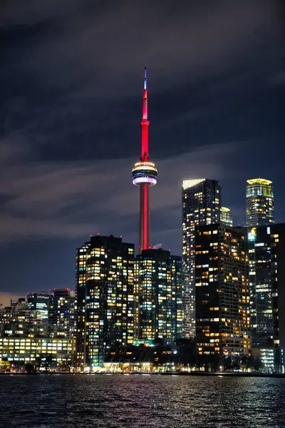 Toronto, Ontario, Kanada 'da Toronto' da Ontario Gölü 'ndeki Toronto Adası' ndan görülen CN kulesiyle Toronto 'nun muhteşem ikonik şehir siluetinin muhteşem gece görüntüsü.