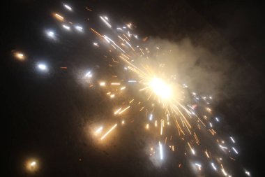 Hindistan 'daki Diwali festivali sırasında çekilen yerde dönen çakra havai fişekleri. Işıltılı kraker kutlaması havai fişekleri yerde ateşliyor.