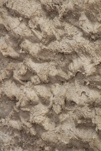 Duvardaki katı olmayan beton alçıyı kapatın. Çıkarılmış şekil arkaplanı ilginç.