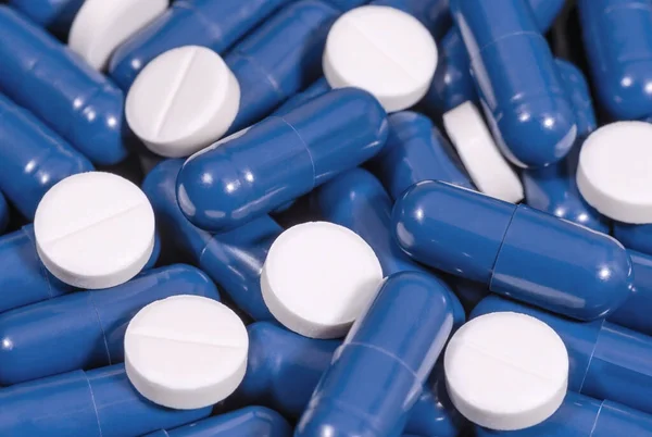 Niebieskie Kapsułki Białe Tabletki Zbliżenie Tle Leki Opieka Zdrowotna Koncepcja — Zdjęcie stockowe