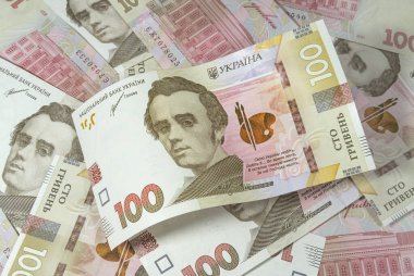 Yüz tane Ukrayna Hrivniası 'nın eğri büğrü banknotu diğer yüz banknotun arka planına karşı. Banknotlar ve madeni paralar