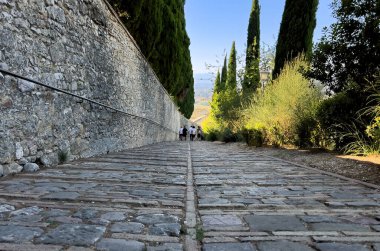 Assisi 'deki taştan yolda yürüyen insanlar.