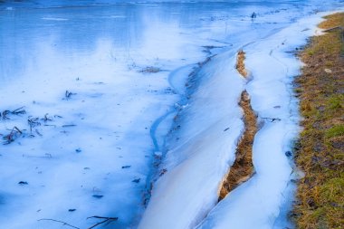 Gauja için buz nehrin kenarında donmuştu. Kış ayının sonu. Seçici odak yumuşak odak.