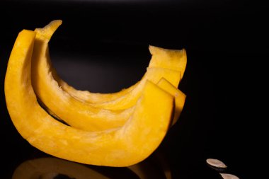 Sarı balkabağı dilimlenmiş siyah arkaplan.