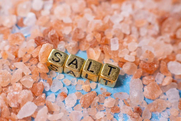 蓝色背景上的红海盐 这个词是由珠子 字母立方体 盐组成的 有选择的软重点 — 图库照片
