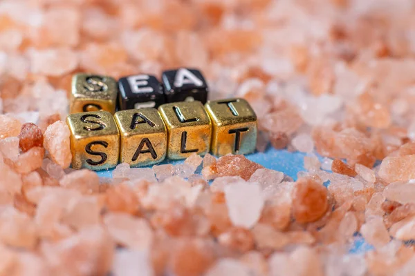 蓝色背景上的红海盐 这个词是由珠子 字母立方体 盐组成的 有选择的软重点 — 图库照片