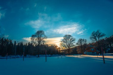 Gauja, kışın kar ve buzla kaplı yüzme yeri. Gün batımı.
