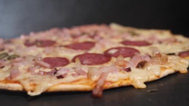Peynirli taze pişmiş salamlı pizza. Sıcaklığı fırından çıkarınca, buhar görülebilir..
