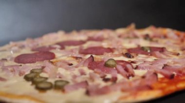 Peynirli taze pişmiş salamlı pizza. Sıcaklığı fırından çıkarınca, buhar görülebilir..