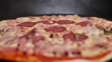 Peynirli taze pişmiş salamlı pizza. Sıcaklığı fırından çıkarınca, buhar görülebilir..