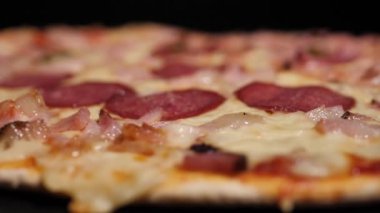 Pizza salamı, jambon ve peynir. Peynirli, taze pişmiş salamlı pizza. Çok güzel dönüyor. Video klipler. Pizza gülümsemesi..