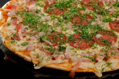 Pizza salamı, jambon, peynir ve otlar, dereotu. Peynirli taze pişmiş salamlı pizza. Bir dilim pizza. Dilimler halinde.