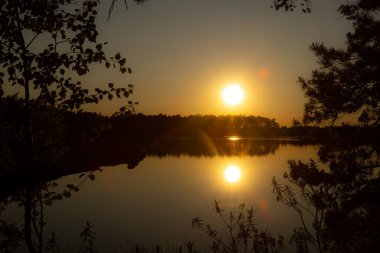 Günbatımı güneşi gölün suyuna yansıyor. Gölde iki güneş, altın güller. İyi akşamlar..