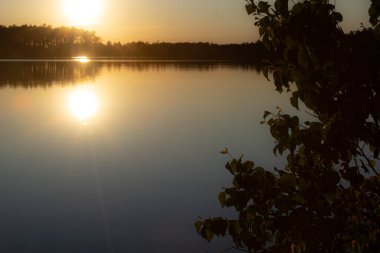 Günbatımı güneşi gölün suyuna yansıyor. Gölde iki güneş, altın güller. İyi akşamlar..
