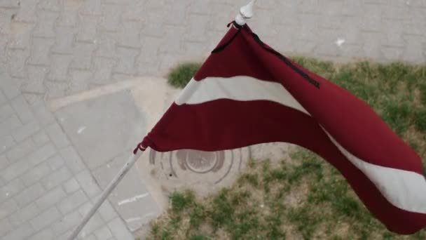 假日的晚上 拉脱维亚国旗在屋前飘扬 — 图库视频影像
