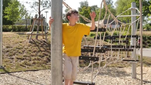Мальчик Поднимается Веревочной Лестнице Игровую Площадку Висит Веревке Прыгает Веревки — стоковое видео