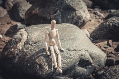 Deniz kıyısındaki kayalarda yaşayan tahta bir adamın silueti. Deniz kenarında tahtadan bir adamın silueti bulundu..