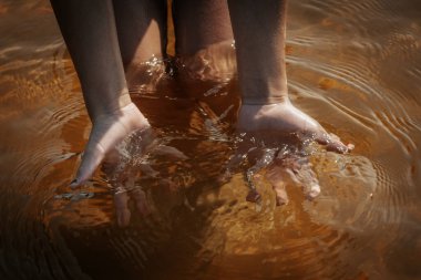 Deniz suyunda bir çocuğun elleri, elleriyle bir denizanası tut. Yumuşak seçici odak.