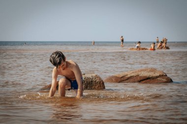 Deniz kenarında egzersiz yapan bir çocuk, yaz tatili. Yumuşak seçici odak.
