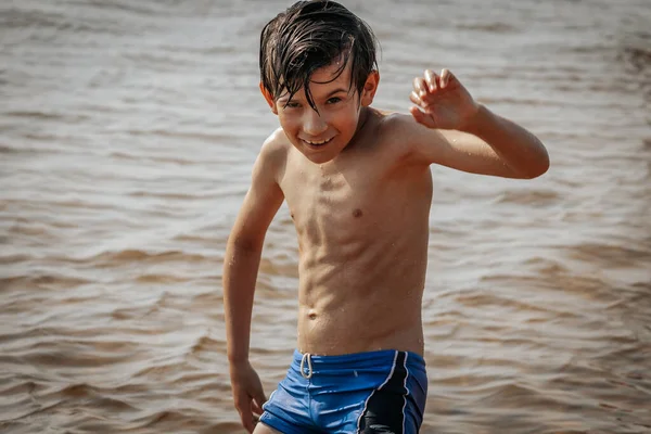 Deniz kenarında egzersiz yapan bir çocuk, yaz tatili. Yumuşak seçici odak.