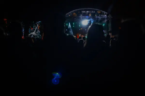 休日の祝祭のためのライトが付いているコンサート ステージ 人々のシルエット ブレイクされた背景 抽象的な色が焦点を当てています ファジー フェアリー ライト ソフトセレクティブフォーカス — ストック写真