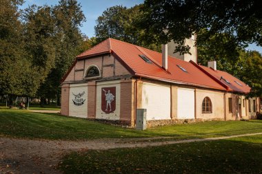 Trikata arması olan bir kır evi. Güzel binaları ve güneşli gökyüzü olan manzaralı bir yer. Kırsalda güzel bir ev..