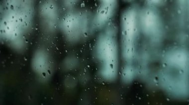Yağmurlu bir hava. Arabayı yolda sürerken, yağmur arabanın camlarına yağar. Şiddetli yağmur damlaları. Yumuşak seçici odaklanma. Resim için yapay olarak tahıl oluşturuldu.