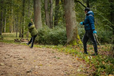 Erkeklerin parkta ağaçlarla kavga etmesi. Yumuşak seçici odak. 