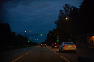 Gece sürüşü, ışıkları açık arabalar görünür durumda. Asp yolu durdu. Yumuşak seçici odak