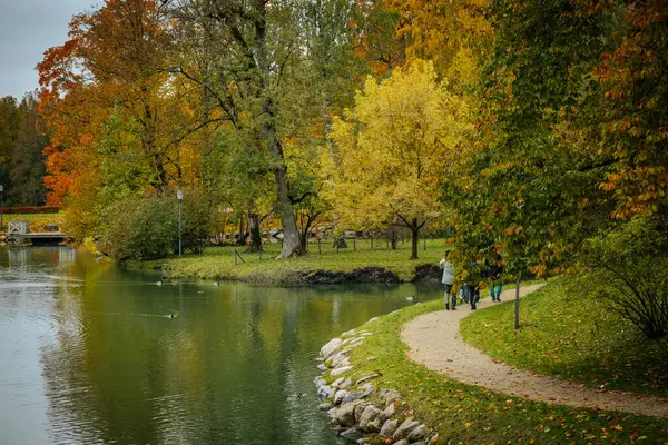 Göl kenarındaki sonbahar parkı. Yürüme yeri. Göl boyunca uzanan yol. Yumuşak seçici odak.