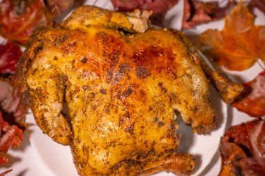 Baharat ve sonbahar yapraklarıyla marine edilmiş kızarmış tavuk. Yumuşak seçici odak.