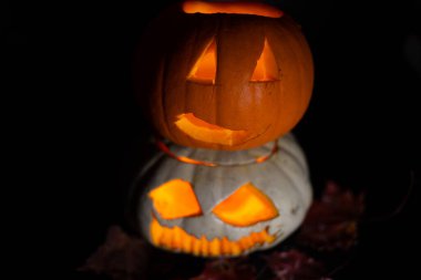 Cadılar Bayramı 'nda balkabağı oyuldu. Siyah arka planda yanan mum ışığı var. Parlak, renkli turuncu bir nesne, sade siyah bir zemin üzerinde, minimum ışıklandırmayla..