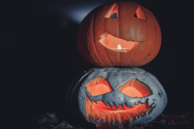 Cadılar Bayramı 'nda balkabağı oyuldu. Siyah arka planda yanan mum ışığı var. Parlak, renkli turuncu bir nesne, sade siyah bir zemin üzerinde, minimum ışıklandırmayla..