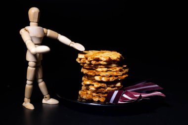 Mutfakta fırında peynirli waffle tutan ahşap bir adam silueti olan karanlık bir arka plan. Yumuşak seçici odaklanma. Resim için yapay olarak tahıl oluşturuldu