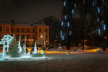 Ren geyikli ve köknar ağaçlı Noel ışıkları, tatillerde dinlenme. Eğlence parkı. Yumuşak seçici odaklanma. Resim için yapay olarak tahıl oluşturuldu