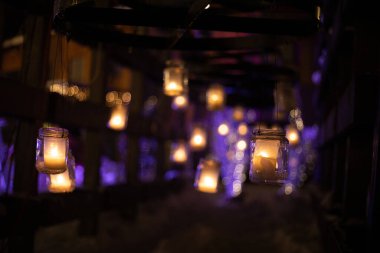 Parlak mimari, gece karanlığında kavanozda bir mumla. Festival binası karanlık bir gecede Noel ışıklarıyla aydınlanır. Atmosferik bozulma, sıcak hava bozulması..