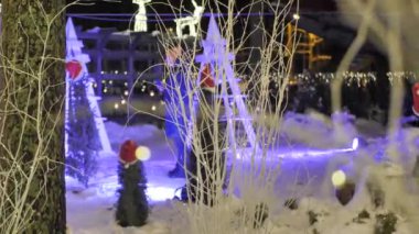 Parktaki Noel ışıkları. Tatil süslemeleri ve yürüyen insanlar. Video klipler. Yumuşak seçici odaklanma. Resim için yapay olarak tahıl oluşturuldu.