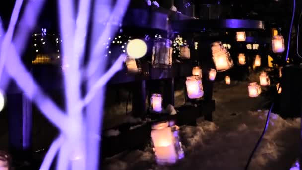圣诞灯亮着 雪下着 假日装饰蜡烛放在玻璃瓶里 有选择性的软重点 人工制造的谷物 — 图库视频影像