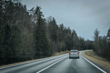 Bahar döneminde araba trafiği olan Valmiera Riga yolu. Ana caddelerdeki Riga binaları. 