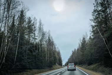 Bahar döneminde araba trafiği olan Valmiera Riga yolu. Ana caddelerdeki Riga binaları. 