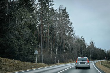 Bahar döneminde araba trafiği olan Valmiera Riga yolu. Ana caddelerdeki Riga binaları. 