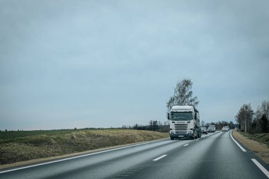 Bahar döneminde araba trafiği olan Valmiera Riga yolu. Ana caddelerdeki Riga binaları. 